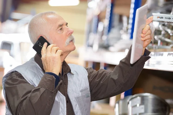 Homme âgé dans les magasins avec téléphone portable et tablette — Photo