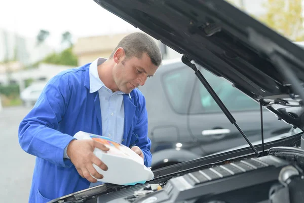 Man refilling vehicle with screen wash — Stock Photo, Image