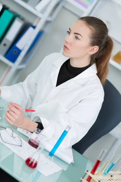 Scientist making notes at desk — Stock Photo, Image