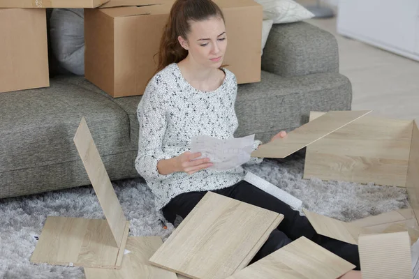 Frustrerade kvinnan sätta ihop själv montering möbler — Stockfoto