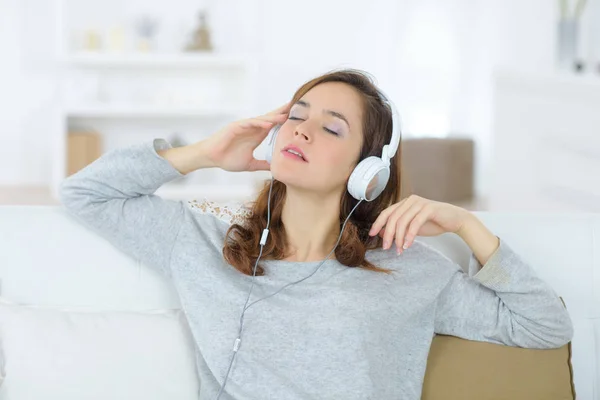 Luisteren naar het lied met behulp van een hoofdtelefoon — Stockfoto