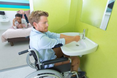 Handicapped man using hotel facilities clipart