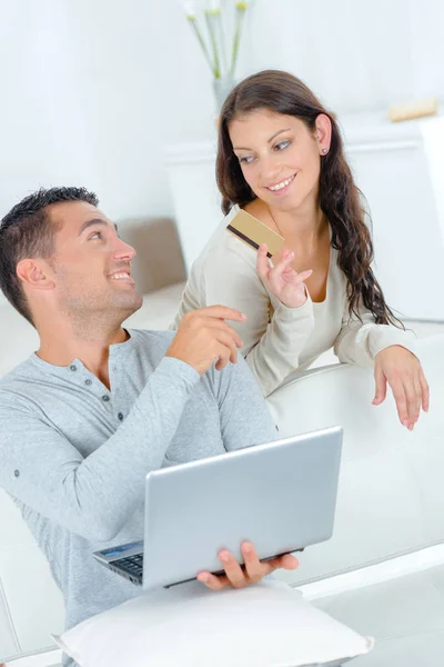 Mujer pasando la tarjeta de crédito a partnet utilizando el ordenador portátil — Foto de Stock