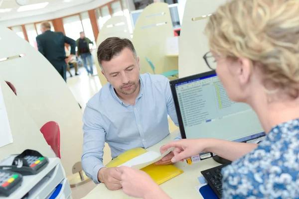 Recepcionista dando forma ao homem — Fotografia de Stock