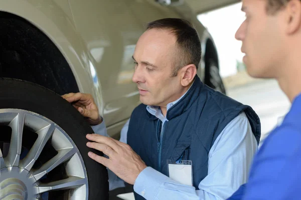 Mechaniker überprüft Autoreifen — Stockfoto