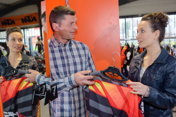 Mujer en la tienda mirando ropa de moto reflectante — Foto de Stock