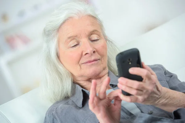 Bejaarde vrouw met behulp van een smartphone — Stockfoto