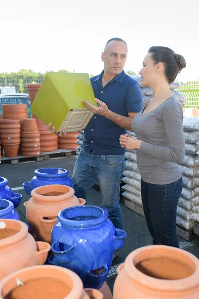 Casal escolhendo grandes vasos de plantas — Fotografia de Stock