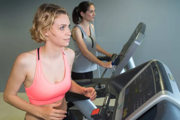 Mulheres trabalhando em equipamentos de exercício — Fotografia de Stock