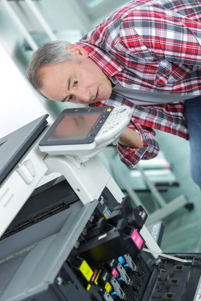 Homem curvando-se para a fotocopiadora — Fotografia de Stock