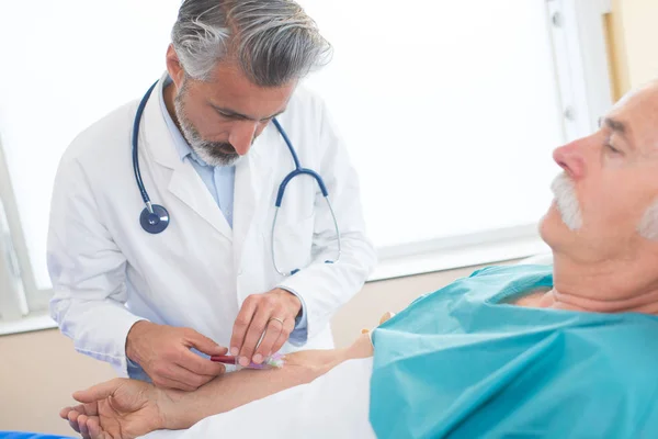 Doctor taking blood from patient s arm — Stock Photo, Image