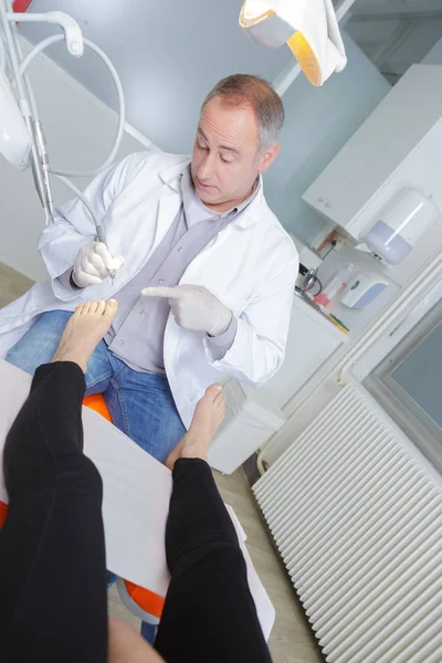 Ортопед указывает на пальцы ног пациента — стоковое фото