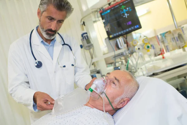 医師が患者の身に着けている酸素マスクする傾向があります。 — ストック写真