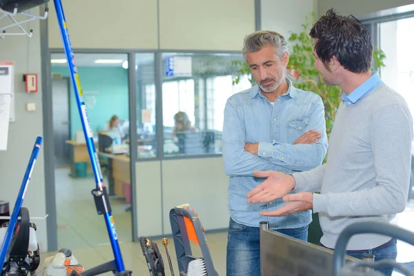 Zwei Männer schauen sich Ausrüstung an — Stockfoto