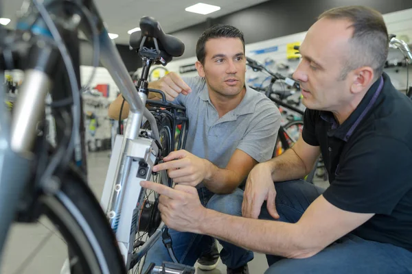 Männer schauen sich Fahrrad im Geschäft an — Stockfoto