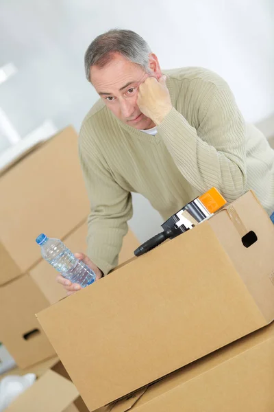 Miserable hombre con sus pertenencias en cajas de cartón — Foto de Stock