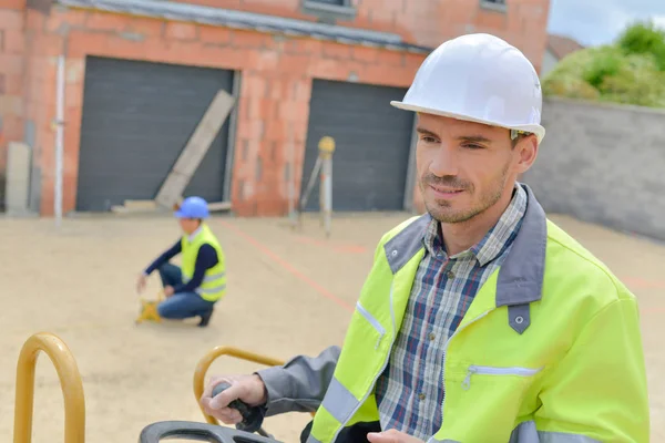 Man using equipment outdoors on building site — Stock Photo, Image