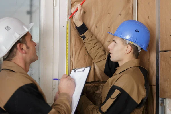 Arbetstagare installera värmeisolering på en byggnad — Stockfoto