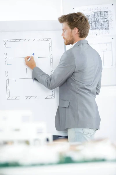 Architect drawing floorplan on easel — Stock Photo, Image