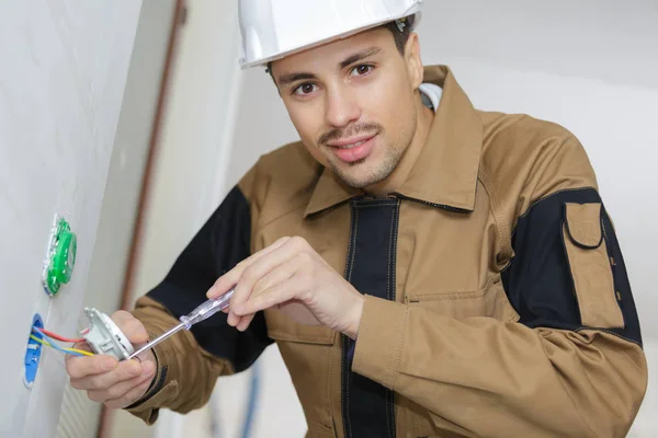 Uomo raccordo una presa elettrica in bagno — Foto Stock