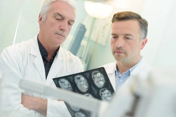 Artsen kijken naar xrays — Stockfoto