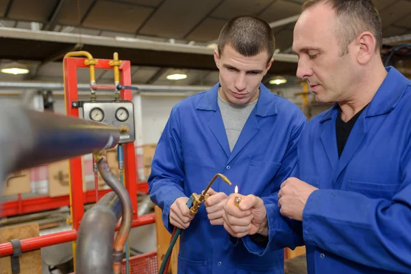 Workers lighting gas torch — Stock Photo, Image