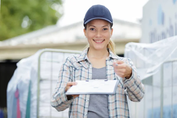 Dame reicht Klemmbrett zur Unterschrift weiter — Stockfoto