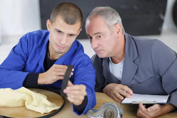 Joven ingeniero mirando correa de goma — Foto de Stock