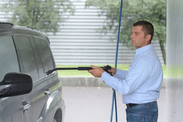 Man wassen voertuig met hogedrukspuit — Stockfoto