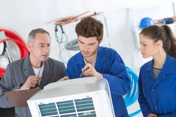 Réparateurs de climatisation discutant du problème avec un groupe compresseur — Photo