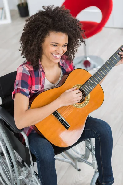 De gelukkige vrouw met een gitaar — Stockfoto