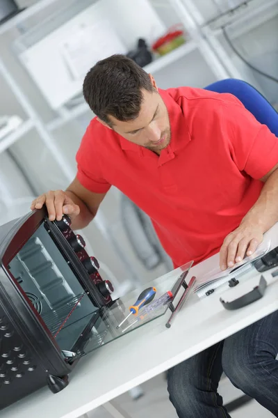 Technicus bezig met teller boven oven — Stockfoto