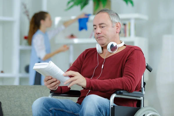 Homme en fauteuil roulant livre de lecture — Photo