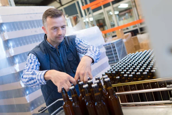 Hombre en planta embotelladora — Foto de Stock