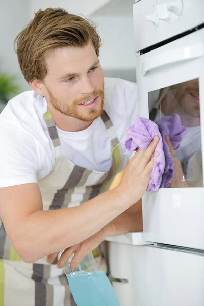 Czyszczenie piekarnika człowieka i czyszczenie — Zdjęcie stockowe