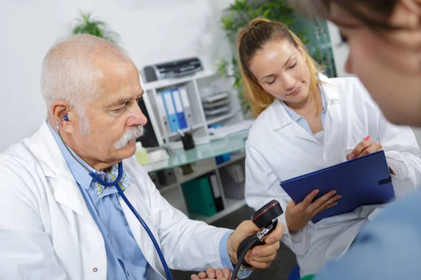 Medico con manometro, assistente che prende appunti — Foto Stock