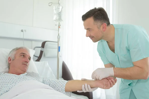 Sjuksköterska hålla patientens arm — Stockfoto