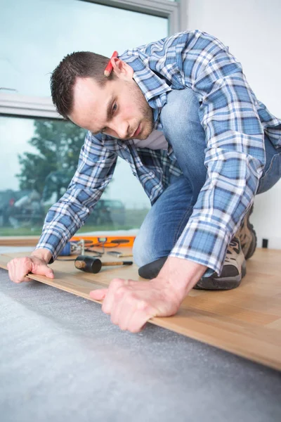 Mann verlegt Parkett zu Hause — Stockfoto