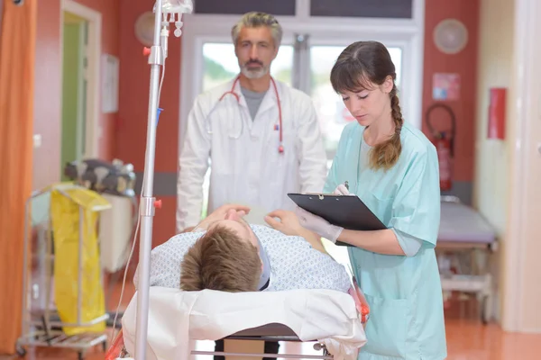 Ärzte transportieren einen Patienten in die Praxis — Stockfoto