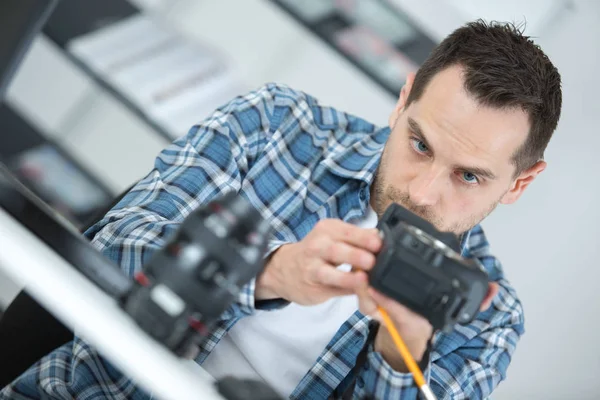 Homem trabalhando em equipamentos de câmera — Fotografia de Stock