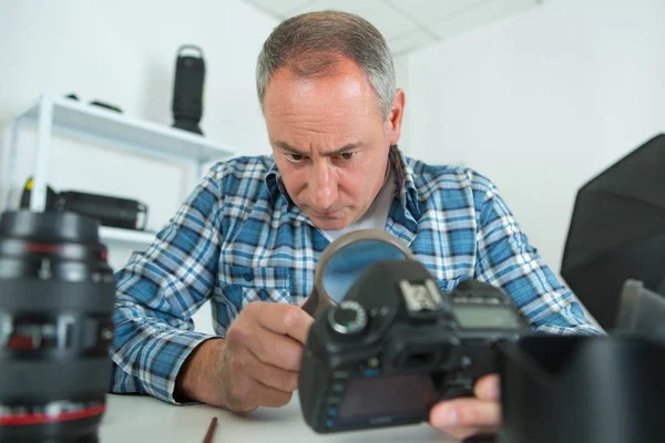 Hombre mayor reparación de equipos de cámara — Foto de Stock