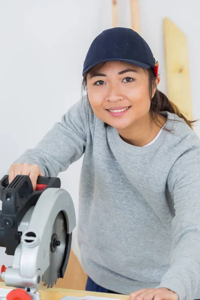 Retrato de mujer usando sierra de banco — Foto de Stock