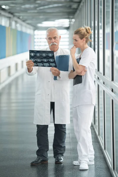 Médicos examinando la radiografía en el pasillo de los hospitales — Foto de Stock