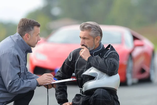 Hombre hablando con piloto de carreras —  Fotos de Stock