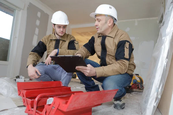 Buiders een gereedschapskist op een site te gebruiken — Stockfoto