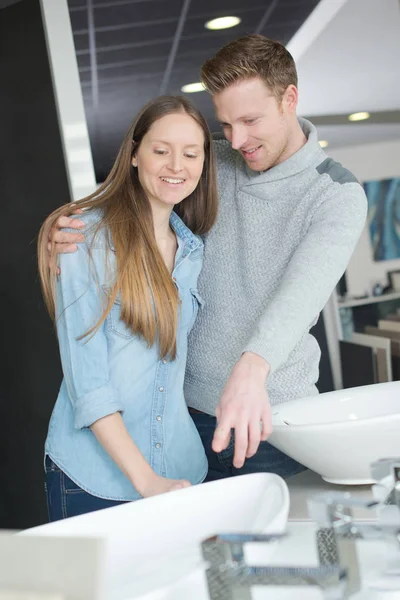 Пара глядя на раковины в ванной в магазине — стоковое фото