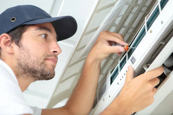 Gerichte klusjesman testen van airconditioning op de muur — Stockfoto