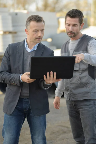 Builder and manager with laptop computer — Stock Photo, Image