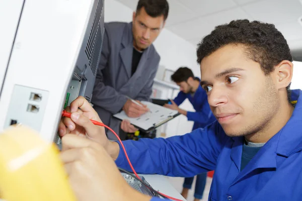 Ung tekniker med hjälp av multimeter — Stockfoto