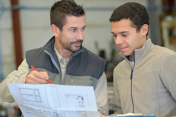 Arbeiter zeichnet an einem Bauplan eines Hauses — Stockfoto